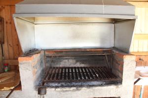 an outdoor brick oven with its door open at Cabañas Alfa Colbun Machicura in Linares