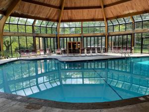 a large swimming pool in a building with a roof at Pocono Paradise - 3 bedroom 3 and half bathroom townhouse in Tannersville