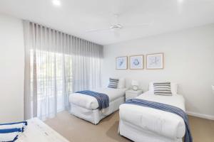 Una habitación blanca con dos camas y una ventana. en Sundowner 3 - Ocean Views near Noosa Main Beach, en Noosa Heads 10 fotos más