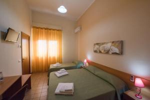 トラーパニにあるCorona Vacanzeのベッド2台と窓が備わるホテルルームです。