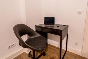 een zwart bureau met een laptop en een stoel bij LivingKreuzberg - Stilvolle Altbauwohnung in Berlijn