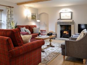 a living room with two couches and a fireplace at Cobblers Cottage in Ripley