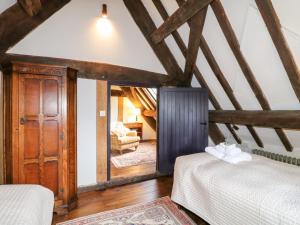 two beds in a room with wooden beams at Gatehouse Croft in Newton Regis