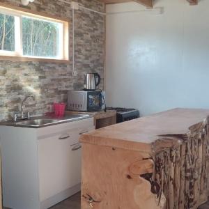 a kitchen with a counter and a sink and a window at Refugio Hualaihue in Hornopiren