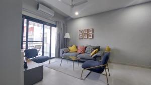 a living room with a couch and two chairs at Superbly Modern and Airy Two Bedroom Seaside Apartment with Balcony in Bijilo