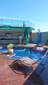 una piscina con terraza y un edificio en Casa de luxo em condomínio, en Arraial do Cabo