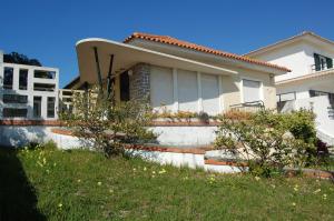 una casa blanca con algunas plantas delante de ella en Casa Belo Horizonte, en Praia da Barra