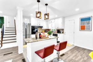 una cocina con armarios blancos y sillas rojas en Modern & Cozy Home mins to Decatur Sq & DT Atlanta!, en Decatur