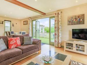 a living room with a couch and a flat screen tv at Foxglove Lodge in Holsworthy