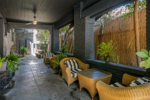 eine Terrasse mit Stühlen, Tischen und einem Zaun in der Unterkunft Venice Beach House in Los Angeles