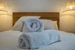 een stapel handdoeken bovenop een bed bij Bellvilla Suites in Merimbula