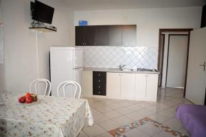 Kuchyňa alebo kuchynka v ubytovaní Apartment in Lopar with sea view, loggia, air conditioning, W-LAN 4229-6 + 32 fotografií