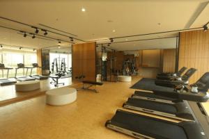 een fitnessruimte met een rij loopbanden en spiegels bij BRANZ -DOJO- 1bedroom in Tangerang