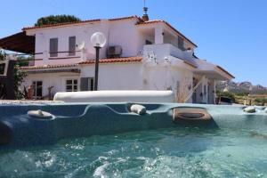 a house with a swimming pool in front of a house at Villa Rosa in Surrau in Arzachena