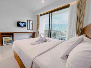 a bedroom with two beds and a large window at Hotel Ariandri Puncak in Puncak
