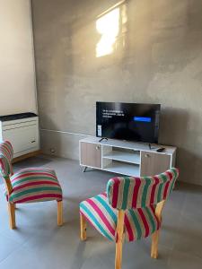 sala de estar con 2 sillas y TV de pantalla plana en Duplex en zona residencial Patagones en Carmen de Patagones