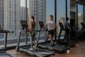 un gruppo di persone sui tapis roulant in palestra di Staybridge Suites Bangkok Sukhumvit, an IHG Hotel a Bangkok