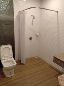 a bathroom with a toilet and a shower at Golden Dragon Resort in Sing Buri