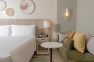 una camera d'albergo con letto e divano di Staybridge Suites Bangkok Sukhumvit, an IHG Hotel a Bangkok