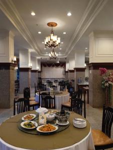 uma sala de jantar com uma mesa com pratos de comida em Golden Dragon Resort em Sing Buri