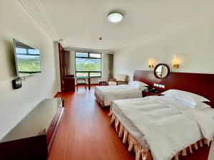 無錫市にある无锡花园大酒店のベッド2台と鏡が備わるホテルルームです。
