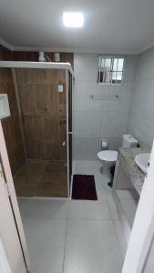 a white bathroom with a shower and a sink at Casa Temporada Waldemar Damasceno - Beira Rio com piscina in Piranhas +31 photos