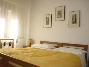 1 dormitorio con 1 cama amarilla y 3 cuadros en la pared en Albergo La Sfinge, en Chiusi