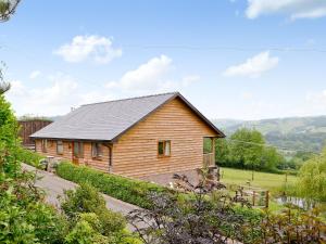 a wooden house with a black roof at The Lodge in Presteigne