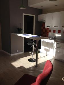 a kitchen with a table and a stool in a room at Appartements d'hôtes Santa Giulia in Niort +24 photos