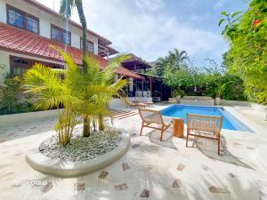 a patio with two chairs and a swimming pool at The Oberoi Luxury Villas Seminyak in Seminyak