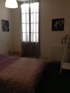 1 dormitorio con cama, ventana y escalera en Appartements d'hôtes Santa Giulia, en Niort