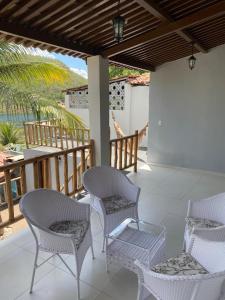 un patio con sillas y una mesa en un porche en Casa Temporada Waldemar Damasceno - Beira Rio com piscina en Piranhas