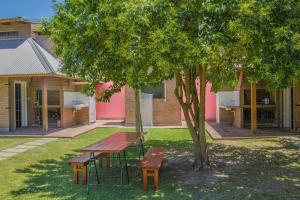 una mesa de picnic y un banco junto a un árbol en Casa Departamento Funes Buena Vista Cochera Pileta en Funes