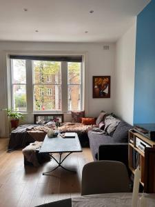 a living room with a couch and a table at Lovely flat near Holland Park in London