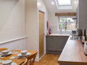 a kitchen with a wooden table and a dining room at Jubilee Cottage in Clifton