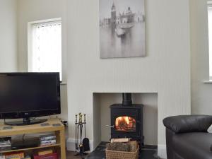 a living room with a fireplace and a tv at Ashlea in Teversal