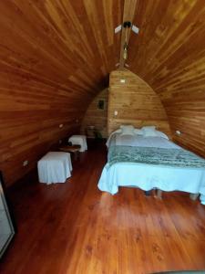 um quarto com uma cama grande num quarto de madeira em Cabañas Nativo D'Ko em Carahuo