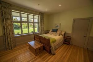 een slaapkamer met een bed en een groot raam bij Waipara River Estate in Waipara