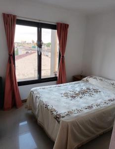 um quarto com uma cama e uma grande janela em Departamento con Cochera Muy Luminoso Gualeguaychú em Gualeguaychú