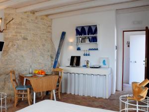 ein Wohnzimmer mit einem Tisch und einer Steinmauer in der Unterkunft I Trulli Sul Mare in Trani