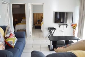 a living room with a blue couch and a bed at Sindy's Chalets in Margate