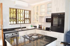 uma cozinha com um lavatório e um fogão forno superior em Sindy's Chalets em Margate