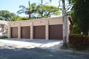 a building with two garage doors in a driveway at Sindy's Chalets in Margate