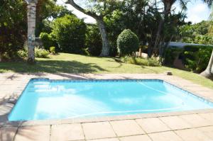 a swimming pool in a yard with trees at Sindy's Chalets in Margate