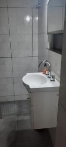 un lavabo blanco en un baño de azulejos blancos en CERRO GODOY CRUZ en Mendoza