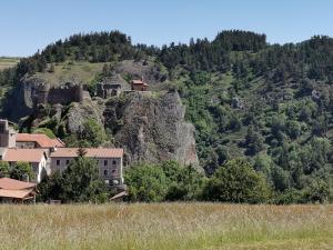un village sur une montagne avec une maison au sommet dans l'établissement Gîte Arlempdes, 5 pièces, 8 personnes - FR-1-582-107, à Arlempdes