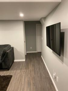 uma sala de estar com um sofá e uma televisão de ecrã plano em 1 Bedroom Modern Secondary Suite em Saskatoon