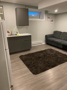 a living room with a couch and a kitchen at 1 Bedroom Modern Secondary Suite in Saskatoon