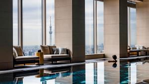 a hotel lobby with a pool with a view of the shard at Four Seasons Hotel Tokyo at Otemachi in Tokyo