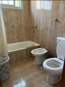 uma casa de banho com um WC e uma banheira em Posada de Los Lirios em Villa Carlos Paz